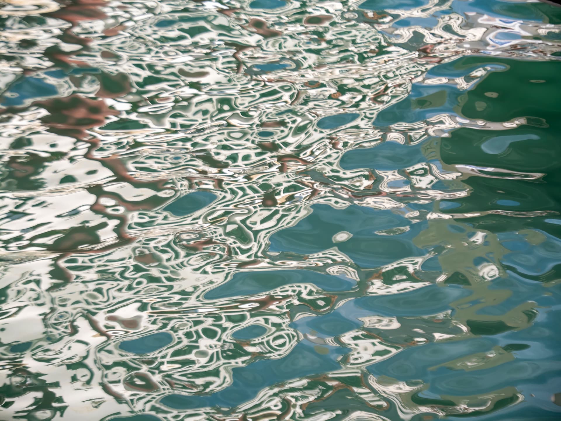 Rippling green water reflecting light and shadow