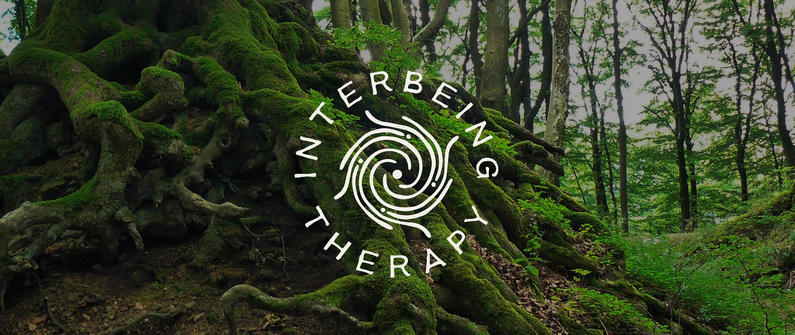 Interbeing Therapy logo over moss-covered tree roots in a forest